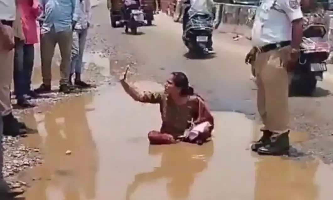 Uppal Woman sits in slush as protest against potholes