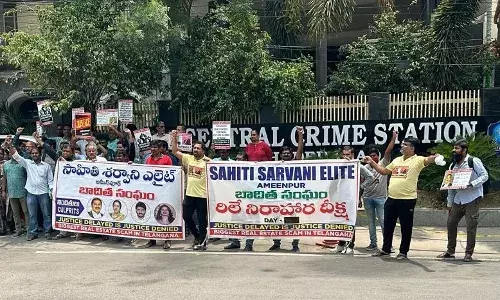 The victims held up posters and a banner featuring the images of the people who they believe are the main culprits.