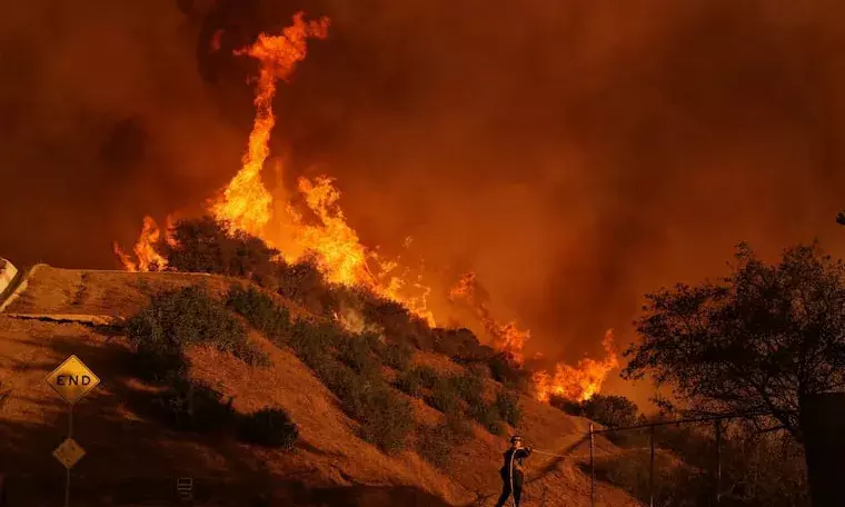 24 dead as fire crews try to corral Los Angeles blazes before winds return this week